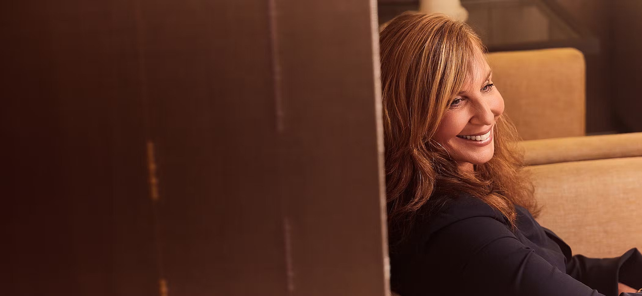 Smiling woman sitting on a couch.