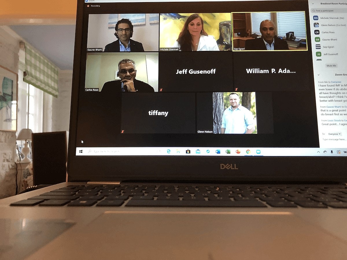 Zoom meeting with multiple participants displayed.
