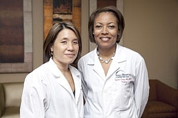 Two doctors smiling in medical coats.
