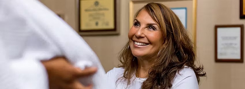 Smiling woman discussing with a patient.