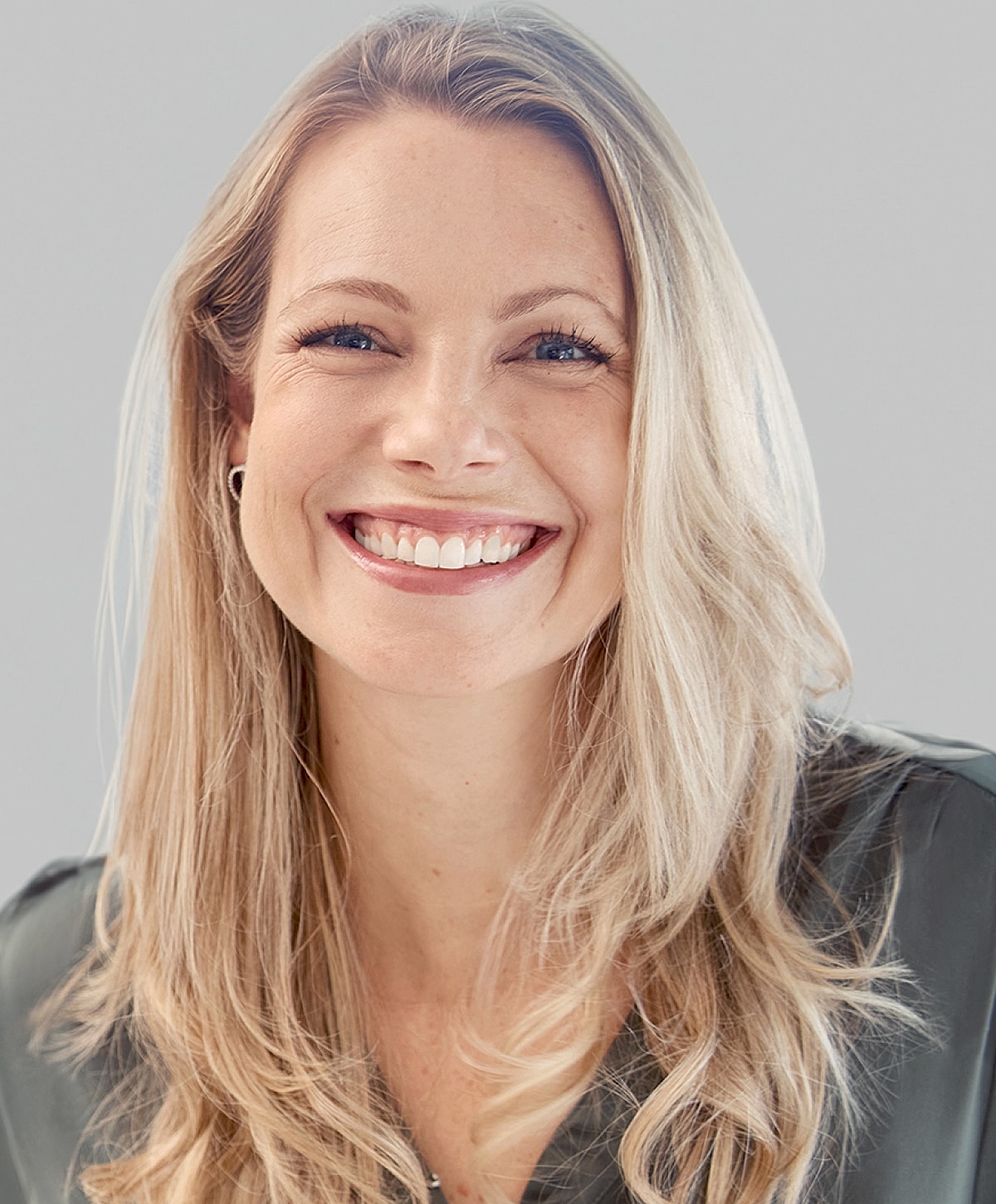 Smiling woman with blonde hair and casual attire.