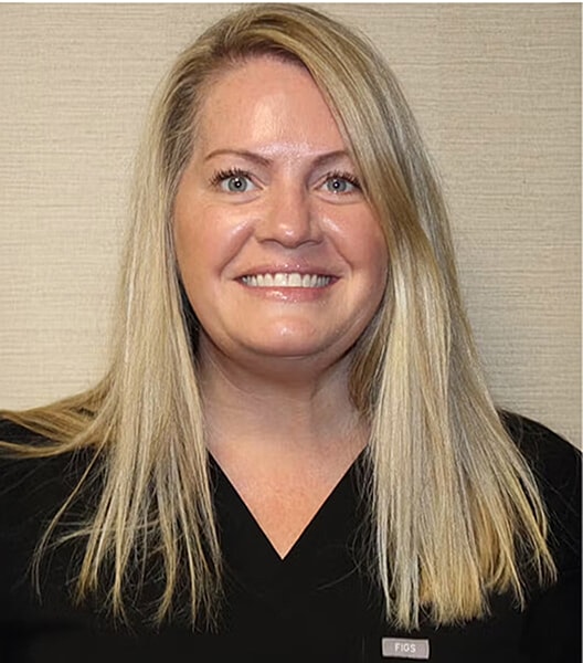 Smiling woman in healthcare attire, looking friendly.