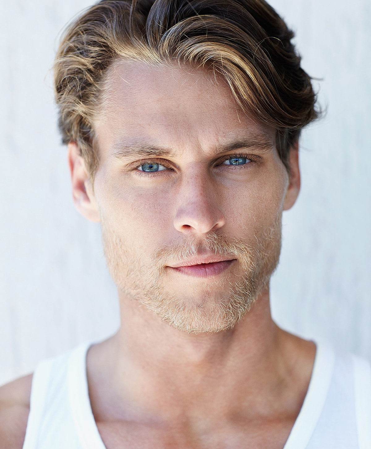 Model posing in a casual white outfit.