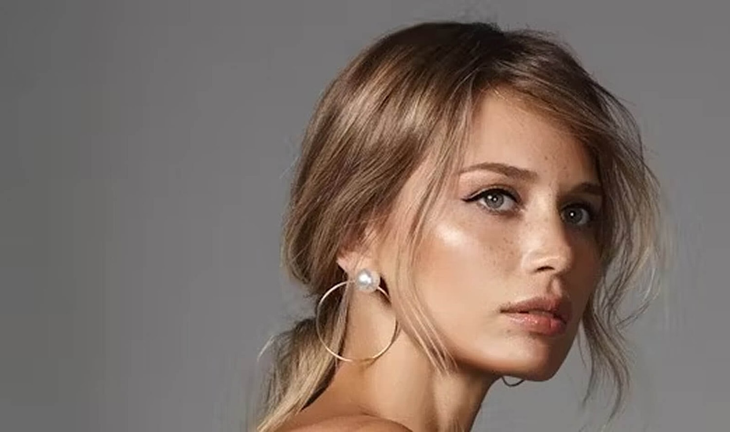 Portrait of a woman with elegant hairstyle and earrings.