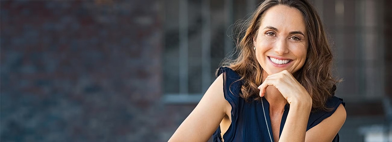Smiling woman in casual outfit, outdoor setting.