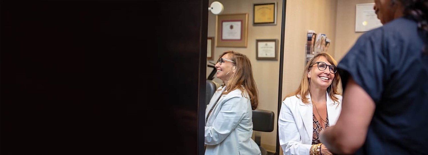 Doctor smiling with patient in consultation room.