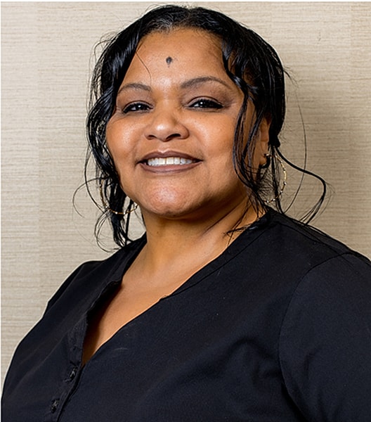 Smiling woman with dark hair in black top.