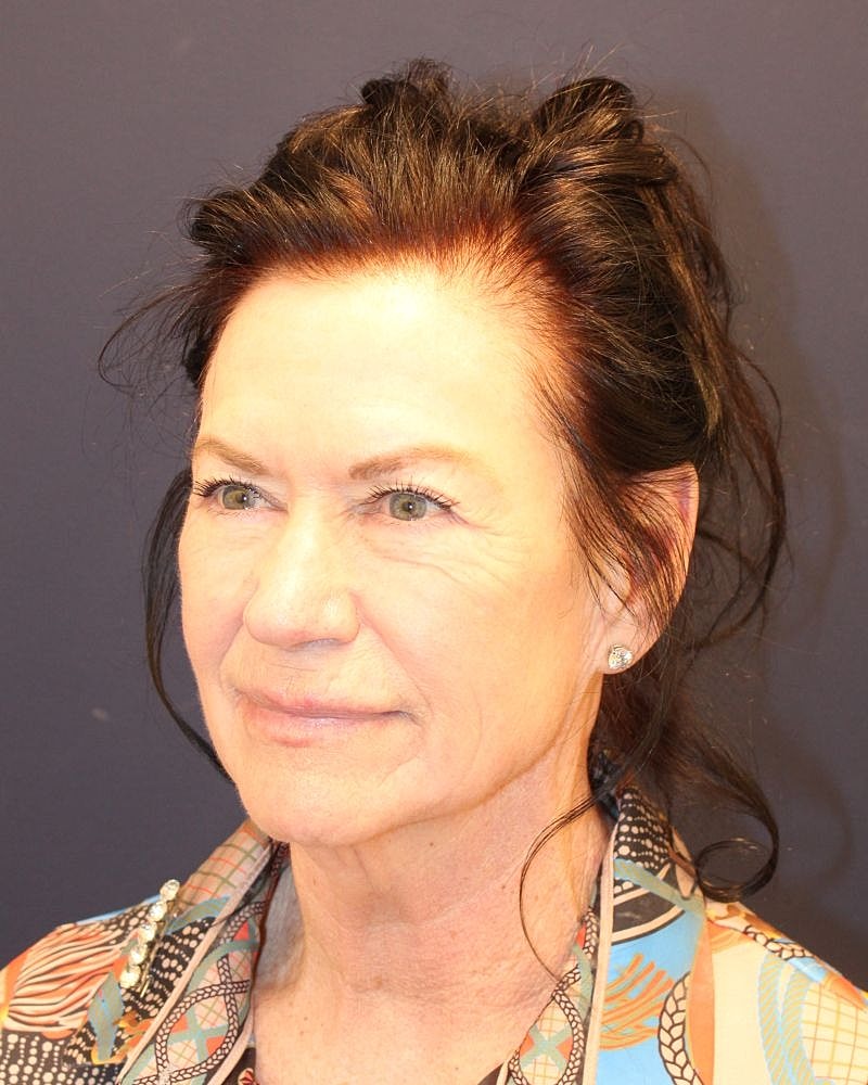 Woman with dark hair and colorful blouse.