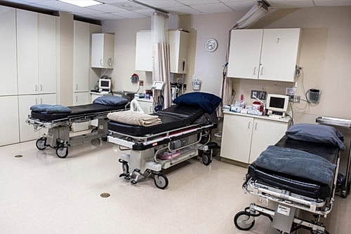 Hospital room with empty medical beds and equipment.