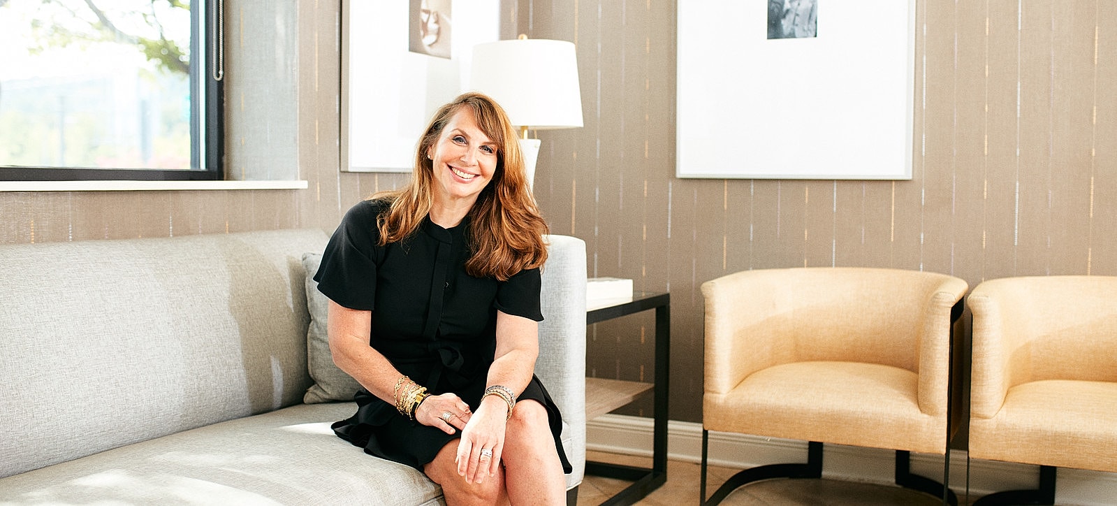 Smiling woman sitting on a couch.
