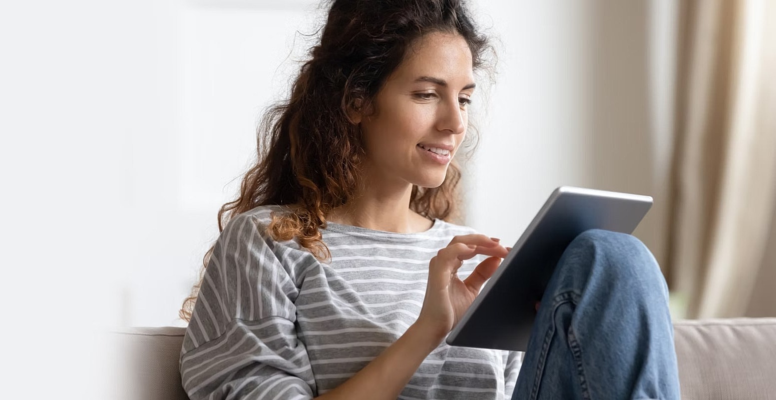 Woman using a tablet while sitting indoors.