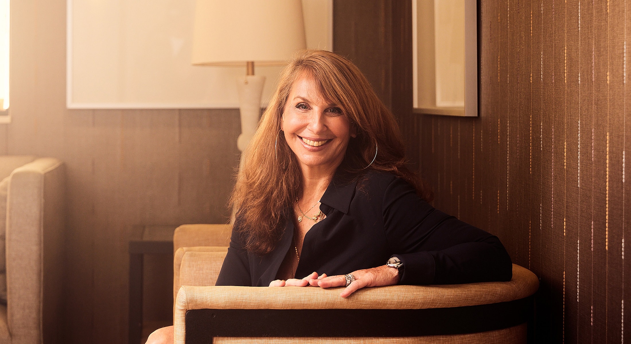 Smiling woman sitting on a couch indoors.