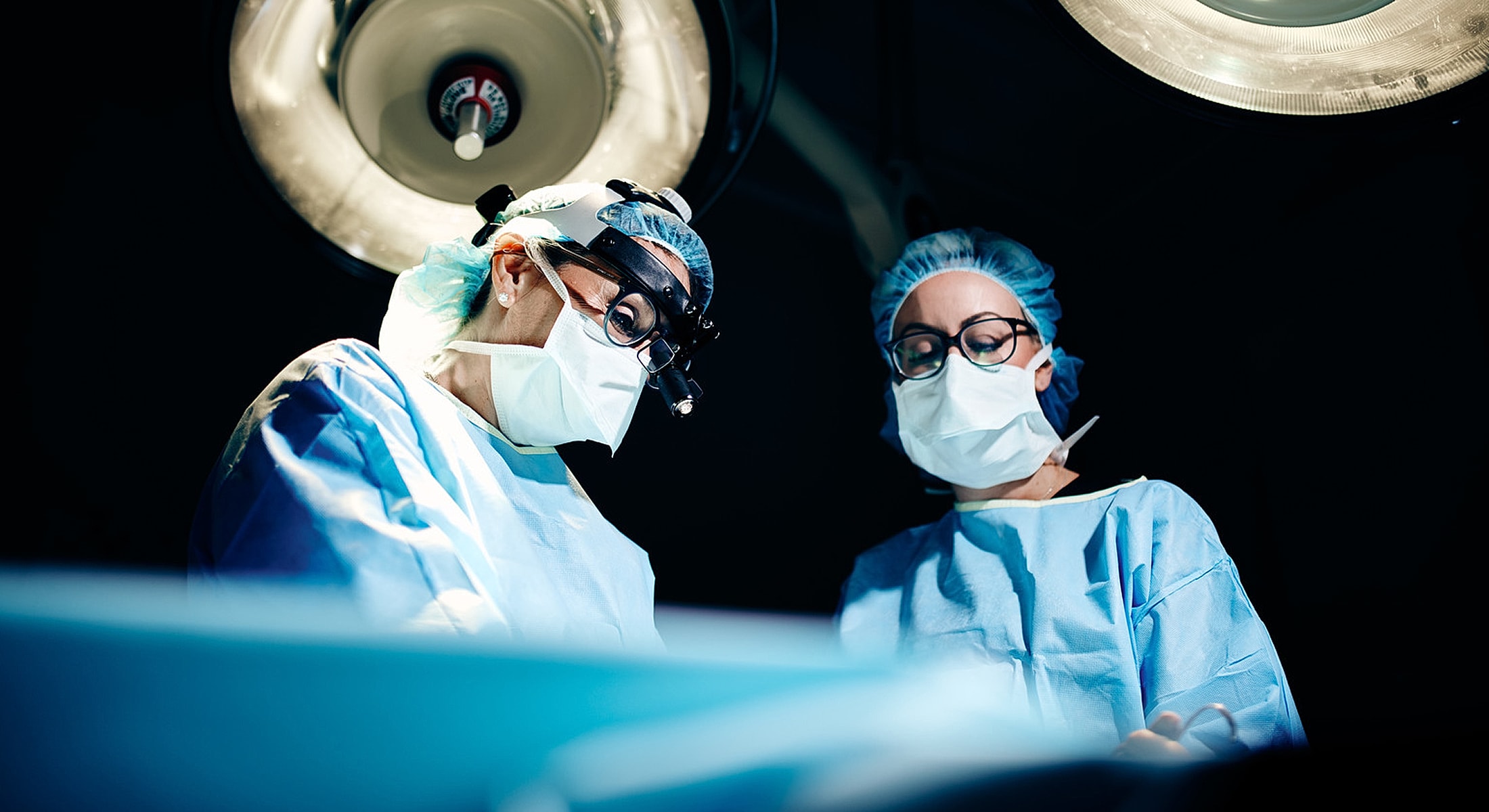 Smiling medical professional in operating room setting.