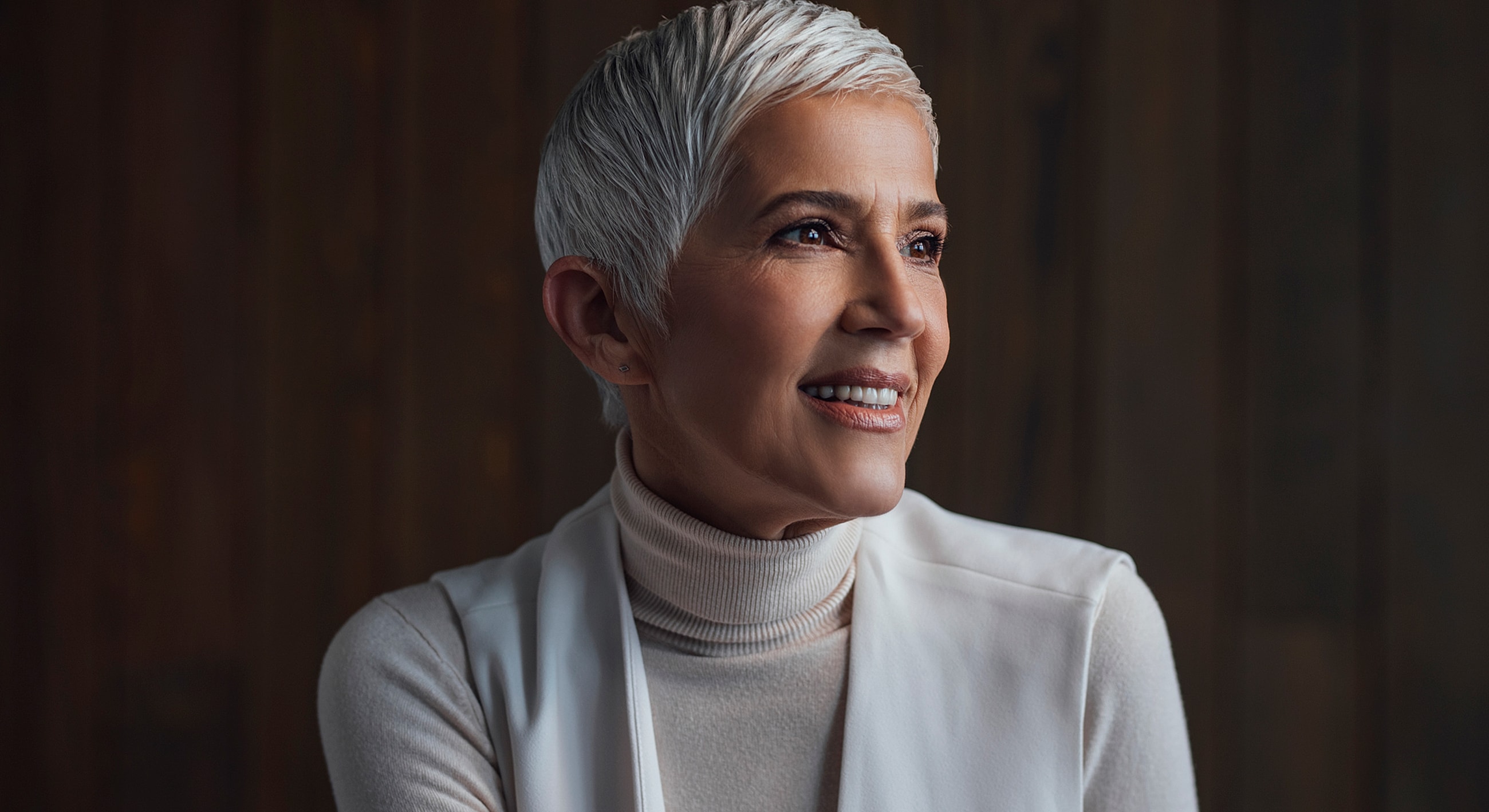 Smiling woman with short, stylish grey hair.