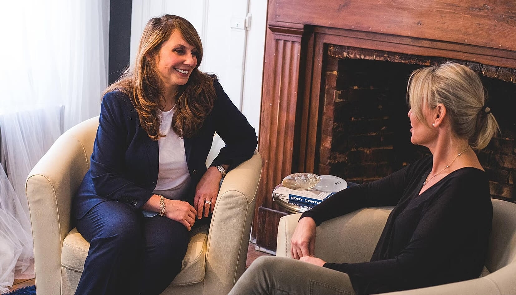 Two women engaged in conversation indoors.