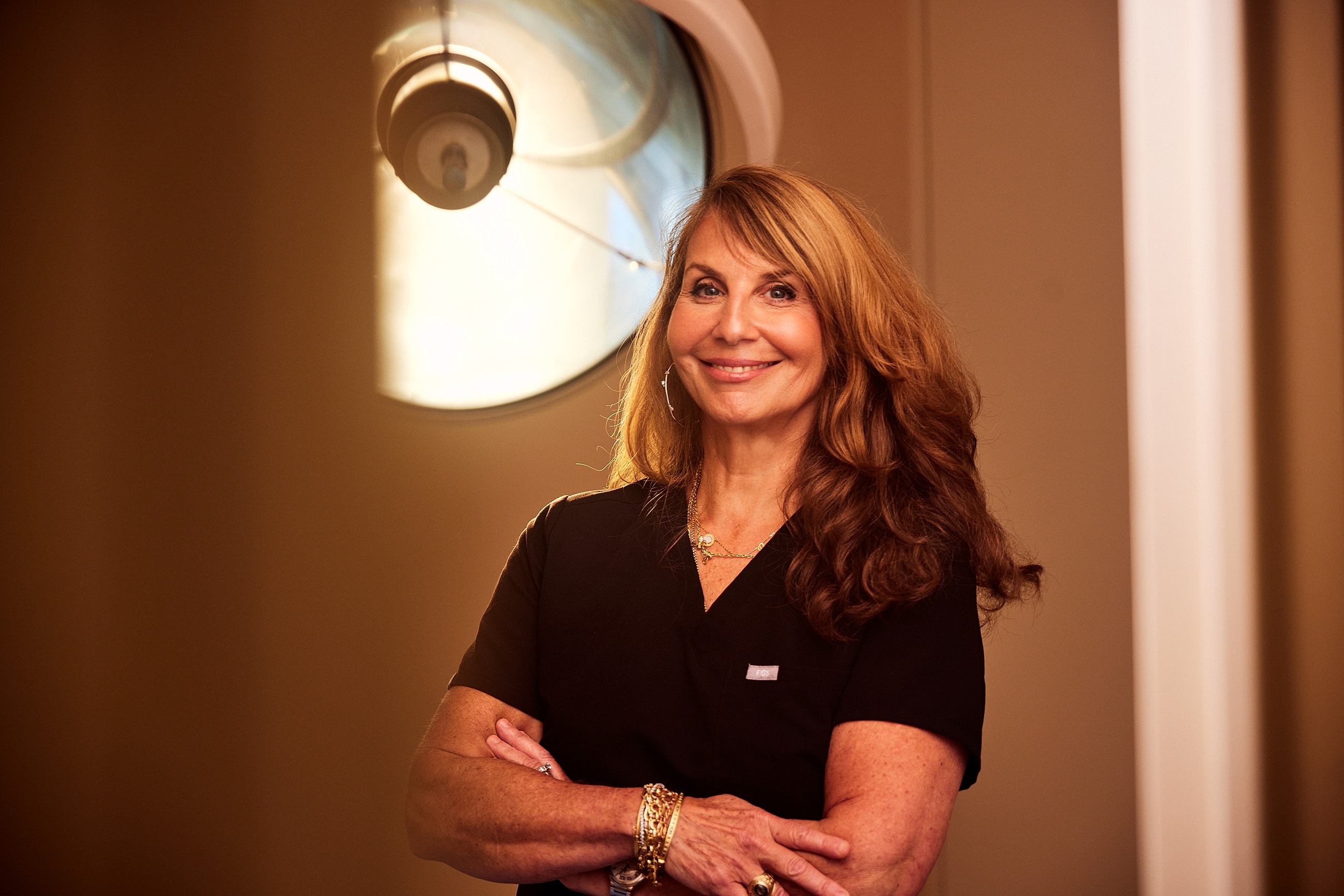 Smiling woman seated in a stylish interior.